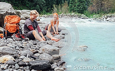 Two travelers refreshing on the mountain riverside Stock Photo