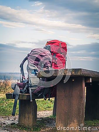 Two trekking mountain climbing hiking backpacks on a wooden bench Stock Photo