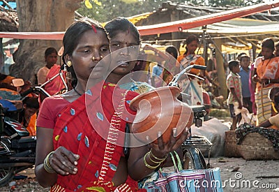 Two Tribal women choosing earthenware in a weekly rural market place. Editorial Stock Photo