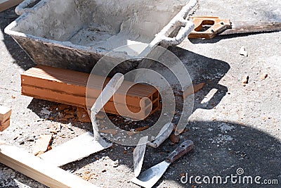Various masonry and brickwork tools being used on a construction site Stock Photo