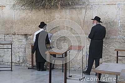 Two ultra-orthodox men in black praying at the Wailing Wall, Jerusalem, Israel Editorial Stock Photo