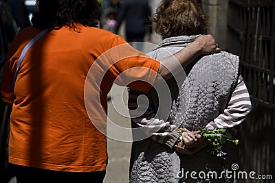 elderly women walk hugging on the street Editorial Stock Photo