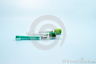 Two vacuum tubes for collection and blood samples and syringe on blue background for laboratory Stock Photo