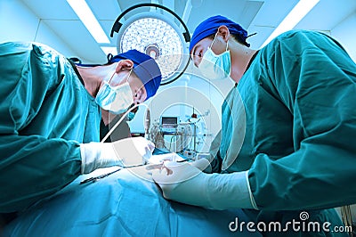 Two veterinarian doctor working in operating room take with art lighting and blue filter Editorial Stock Photo