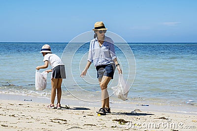 Two volunteers picking plastic waste on the beach Stock Photo