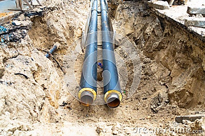 Water pipes in ground pit trench ditch during plumbing under construction repairing Stock Photo