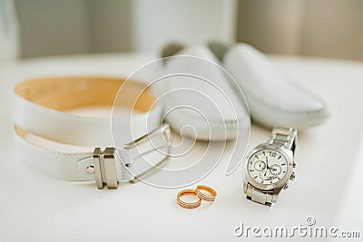 Two wedding rings with accessories for the groom. Wrist watch, leather belt and shoes on a white background. Stock Photo