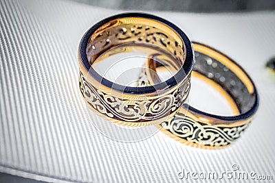 Two wedding rings with rare design on white broad ribbon Stock Photo