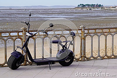 Two wheeled electric black scooter with large wide wheels on sea side Stock Photo