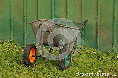 Two-wheeled garden trolley against a green wall Stock Photo