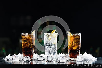 Two whisky and coke cocktails and one white alcoholic drink on the bar table. Stock Photo