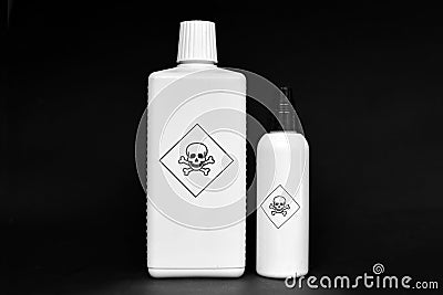 Two white bottles with poison warning signs on them on black background Stock Photo