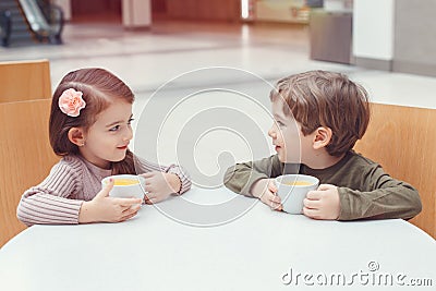 Two white Caucasian cute adorable funny children drinking talking Stock Photo