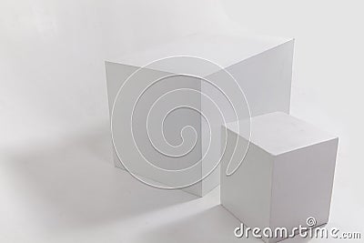 Two white cubes on white wall Stock Photo