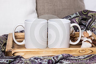 Two white mugs, pair of cups on a wooden tray, the Mockup. Cozy home, wooden background, cotton and wool decorations, winter gifts Stock Photo