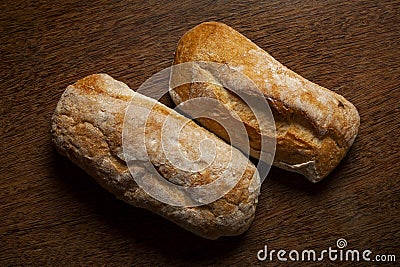 Two whole grain breads on wooden table. Stock Photo