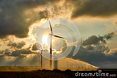 Two wind turbines and irrigating crop water gun Stock Photo