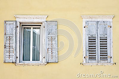 Two windows with window shutters in a yellow house Stock Photo