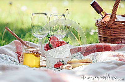 Two wine goblets, fresh strawberry, honey and wine are served for summer romantic picnic Stock Photo