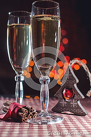 Two wineglasses of champagne and new year`s decoration and cinnamon on the bokeh background Stock Photo