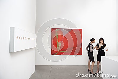 Two woman standing next to wall paintings Stock Photo