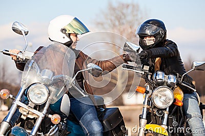 Two women bikers greeting each other with fists blow, usually gesture of motorcyclists Stock Photo