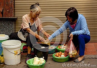 Two women buying and selling fresh eggs in the Old Quarter of Hanoi, Vietnam Editorial Stock Photo