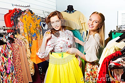 Two women choosing yellow skirt in shop Stock Photo