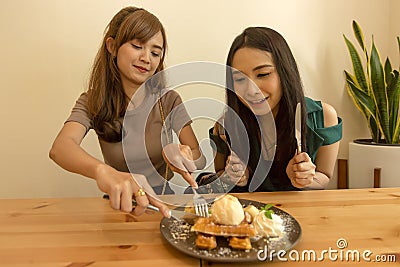 Two women consuming sweet healthy dessert in a restaurant, talking and spending time together. Clean eating. Stock Photo