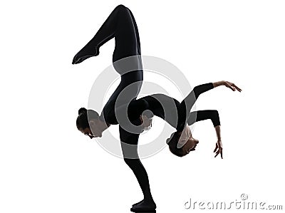 Two women contortionist exercising gymnastic yoga silhouette Stock Photo