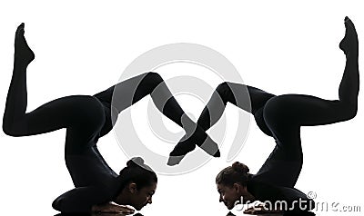 Two women contortionist exercising gymnastic yoga silhouette Stock Photo