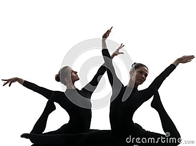 Two women contortionist exercising gymnastic yoga silhouette Stock Photo