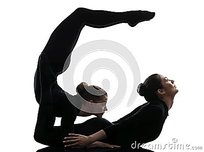 Two women contortionist exercising gymnastic yoga silhouette Stock Photo