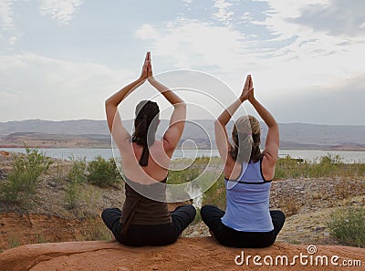 Two Women Doing Yoga at Sunset Stock Photo