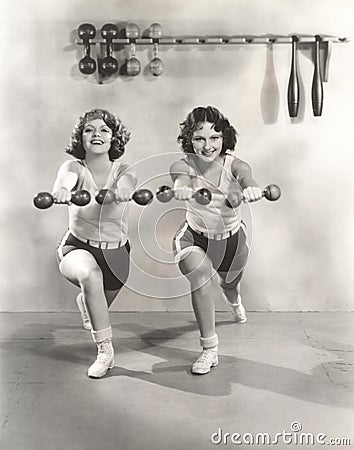 Two women exercising with dumbbells at gym Stock Photo