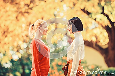 Two women are facing each other. girls looking into each others eyes. female friendship. walking in sunny park. best Stock Photo