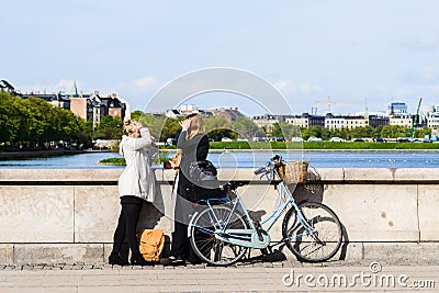 Two women have conversation on bridge, city bike Editorial Stock Photo