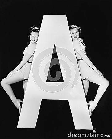 Two women with huge letter A Stock Photo