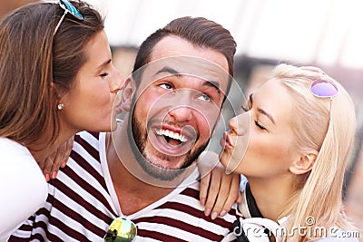 Two women kissing a man Stock Photo