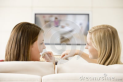 Two women in living room watching television Stock Photo