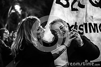 Two women looking at a phone during International Women Day 8 March demonstration in Madrid Editorial Stock Photo