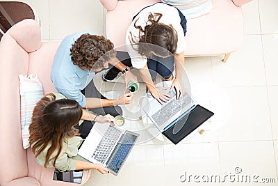Two women and one man businessmen working informally on their computers in their office chairs Stock Photo