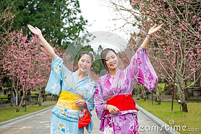 Two women open arms with cherry-blossom Stock Photo