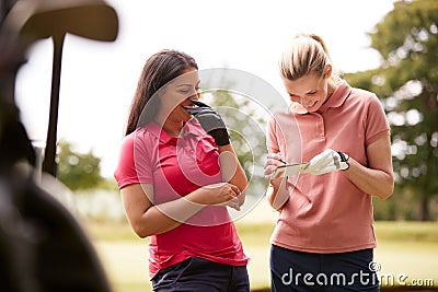 Two Women Playing Golf Marking Scorecard With Buggy In Foreground Stock Photo