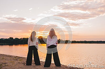 Two women practicing yoga meditation at sunrise. Back view Stock Photo