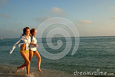 Two women running on beach Stock Photo