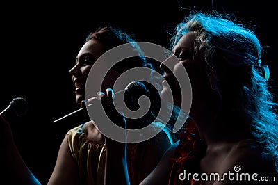 Two women singing in microphone Stock Photo