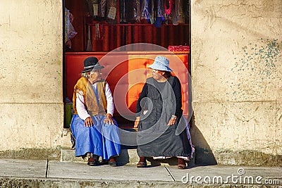 Two Women Sitting In Front Of A Shop in Bolivia Editorial Stock Photo
