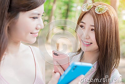 Two women use phone happily Stock Photo
