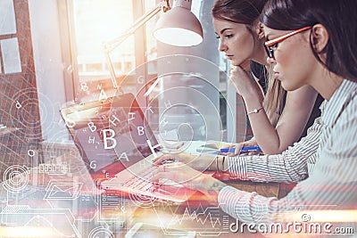 Two women working on new website design choosing pictures using the laptop surfing the internet Stock Photo